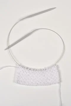 Knitting process with circular needles on white background 库存照片