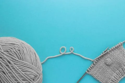 Knitting project in progress.  A piece of knitting with ball of gray wool yarn Foto stock