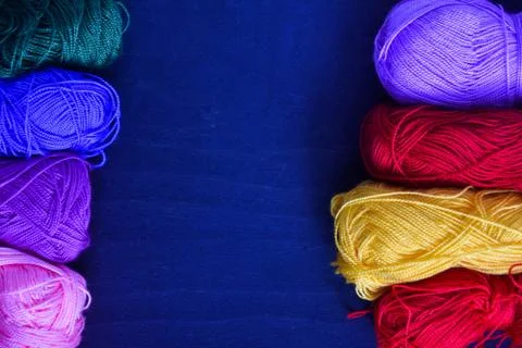 Knitting threads on a blue background Stock Photos
