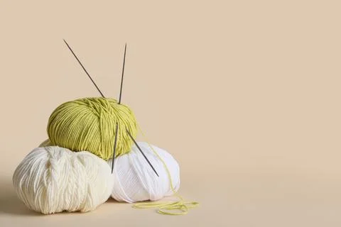 Knitting yarn and needles on beige background Stock Photos