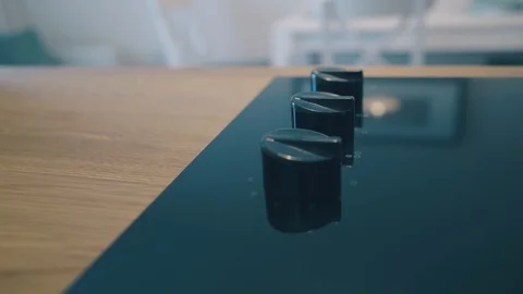Knobs at black electric stove at wooden counter in kitchen Video stock 120401427