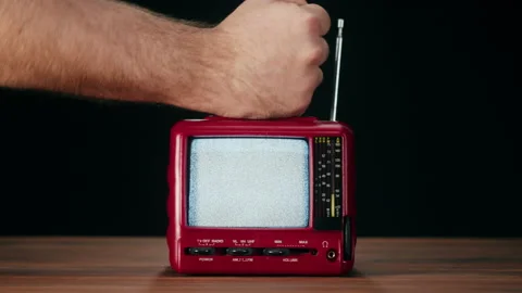 Knocking on small old television with grey interference screen on black Video stock 169309840