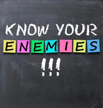 Know your enemies text on a blackboard with chalk and stickers Fotos Stock