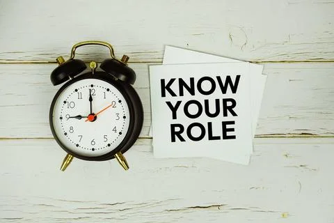 Know Your Role text message on sticky note with alarm clock on wooden backg.. Stock Photos