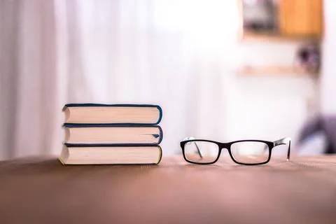 Knowledge and science concept: Stack of books and glasses lying on wooden ... Stock Photos