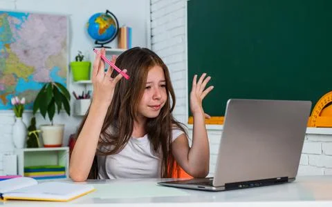 Knowledge day. child pupil sit at table and use computer. girl is college 写真素材