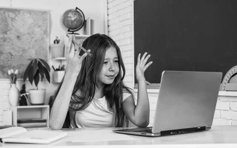 Knowledge day. child pupil sit at table and use computer. girl is college 写真素材