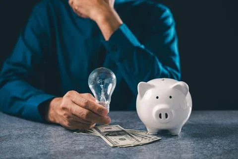 Knowledge fuels financial innovation while businessman holds lightbulb near.. Stock Photos