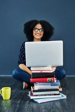 Knowledge is the greatest tool. Studio shot of a young woman using a laptop with Stock Photos