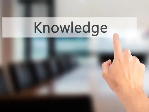 Knowledge - Hand pressing a button on blurred background concept on visual sc Stock Photos