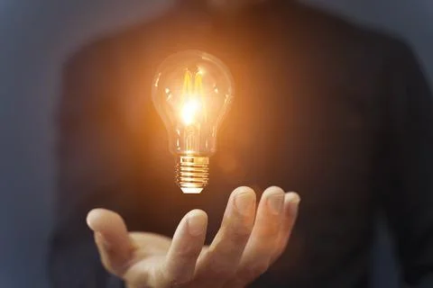 Knowledge idea bulb concept. Electric light bulb in hand business manager Stock Photos