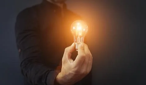 Knowledge idea bulb concept. Electric light bulb in hand business manager Stock-Fotos