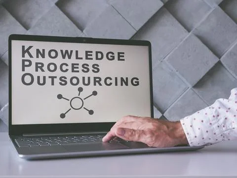 Knowledge Process Outsourcing KPO concept. Man uses laptop. Stock Photos