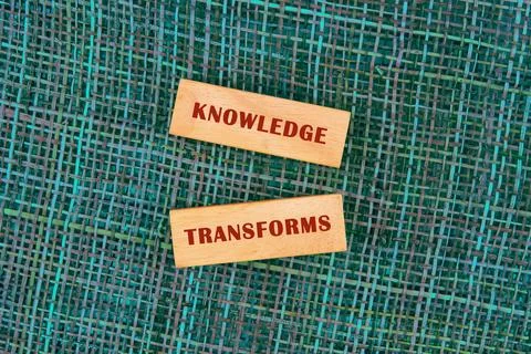 KNOWLEDGE TRANSFORMS concept words made of wooden blocks on fabric background Stock Photos