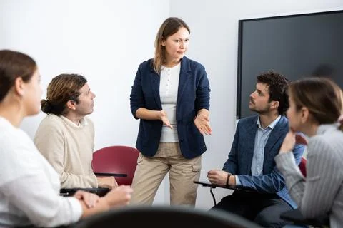 Knowledgeable female professor explaining subject to classroom full of students Stock Photos