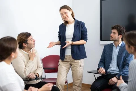 Knowledgeable female professor explaining subject to classroom full of students Stock Photos