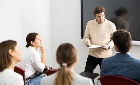 Knowledgeable professor explaining subject to classroom full of students Stock Photos