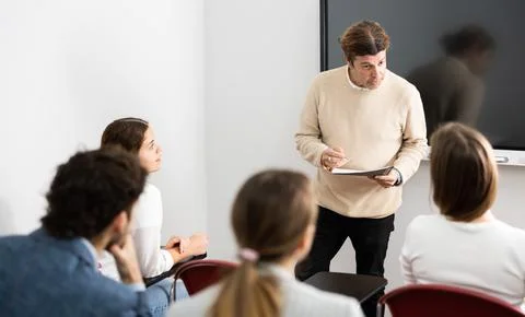 Knowledgeable professor explaining subject to classroom full of students Stock Photos