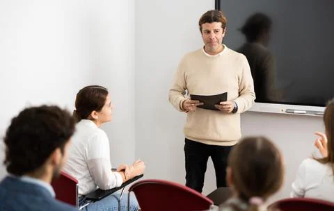 Knowledgeable professor explaining subject to classroom full of students Stock Photos