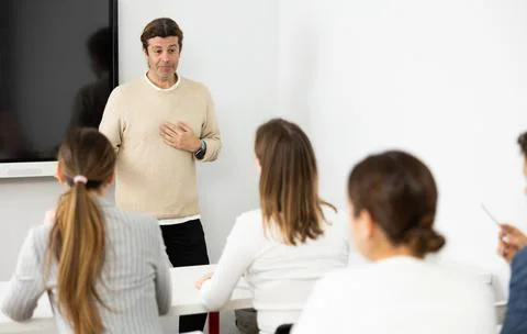 Knowledgeable professor explaining subject to classroom full of students Stock Photos