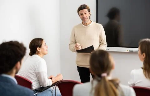 Knowledgeable professor explaining subject to classroom full of students Stockfoto's