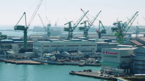 Kobe port / dock with cranes lifting freight and Kawasaki building in foreground Video stock 130376355