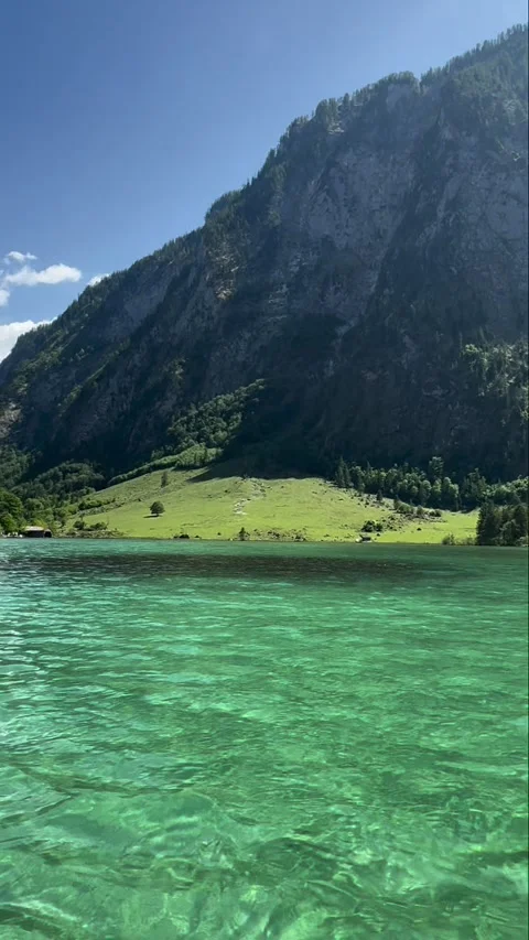 Koenigssee steep cliffs green meadow and clear turquoise water 스톡 동영상 341768871