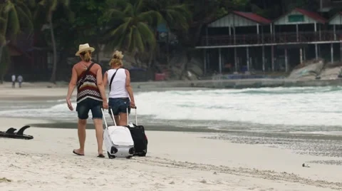KOH PHANGAN, CIRCA 2015: two young girls are walking along beach with luggage Stock Footage 63177986