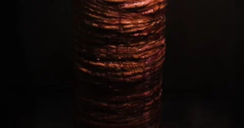 Kokoreç slowly cooking while rotating against a black background Video stock 293093207