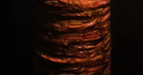 Kokoreç slowly cooking while rotating against a black background Stock Footage 293094022