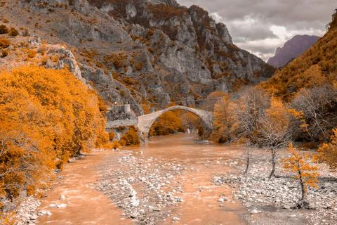 Konitsa city arced bridge and voidomatis river in autumn , greece Stock Photos