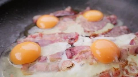 Kooking bacon and eggs in a pan Stock Footage 289290133