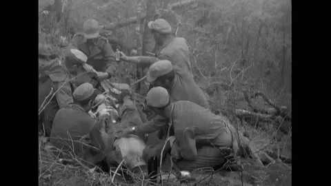 KOREA - 1952 - Man lying on ground receiving transfusion as several men stand Stock Footage 323265262