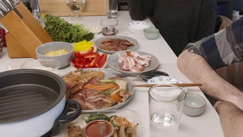 Korean barbecue at home dining with friend chatting over the table Stock Footage