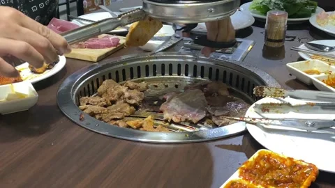 Korean BBQ meat grilling in the tabletop pan Stock Footage 125193591