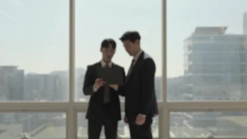 Korean Businessmen Talking and Gesturing by Office Window Stock-Footage 338046717