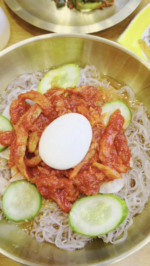 Korean cold noodles with raw fish, naengmyeon. Sliced cucumber, pickled radish 스톡 동영상 338237783