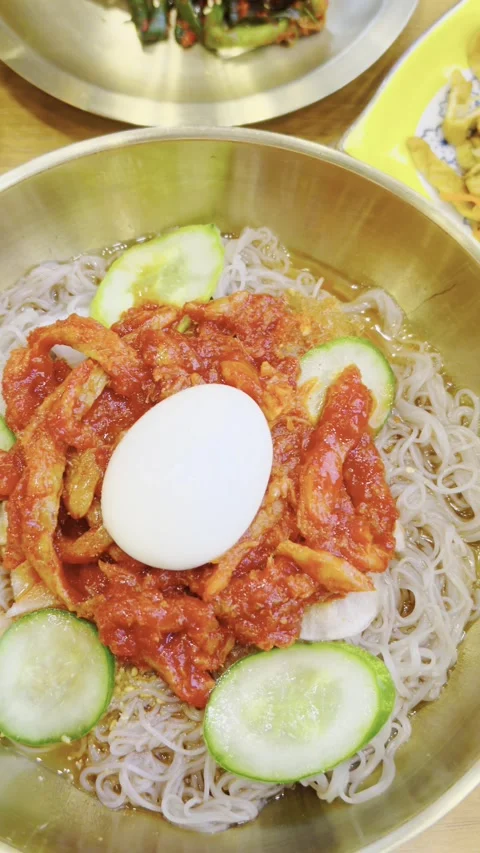 Korean cold noodles with raw fish, naengmyeon. Sliced cucumber, pickled radish Stock Footage 339274585