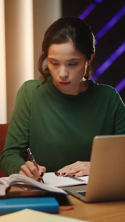 Korean female student does research, writing notes and reading a library book Stock Footage 343664802