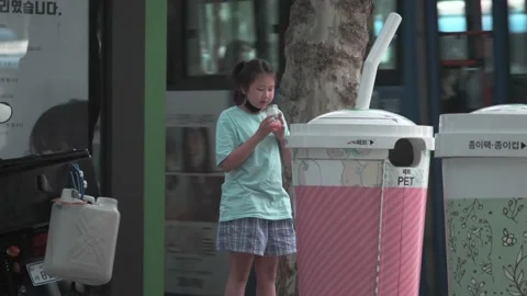 Korean girl throws plastic cup into recycle Stock Footage 132937896