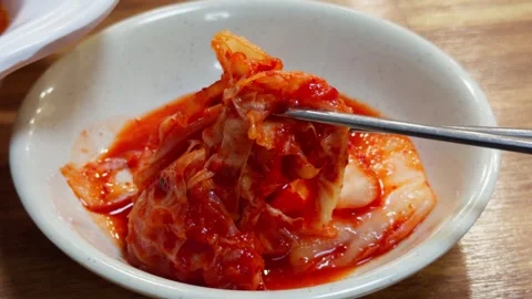 Korean Kimchi Small Dish Lifted by Chopsticks Close-Up Traditional Side Dish Stock Footage 340385604