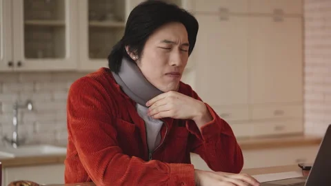 Korean man in cervical neck collar working on laptop as freelancer, feeling pain Stock Footage 330400738