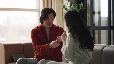 Korean man making a proposal to loving girlfriend, presenting engagement ring Stock Footage 330401686