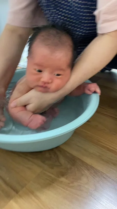 Korean newborn given a bath; Vertical Stock Footage 317433168