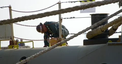 A Korean shipyard worker finishes work on the deck of a ship. Stock Footage 166390742