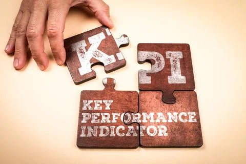 KPI Key Performance Indicator Concept with Wooden Puzzle Pieces and Hand Stock Photos