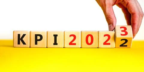 KPI, key performance indicator symbol. Businessman turns wooden cubes with wo Stock Photos