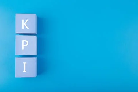 KPI letters on light blue cubes against dark blue background with copy space Stock Photos