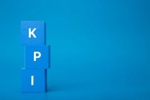 KPI letters on stack of blue toy cubes against dark blue background with copy 스톡 사진