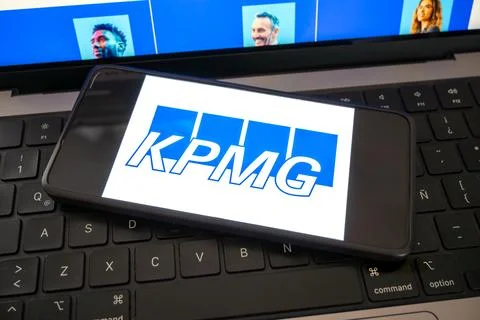 Kpmg logo on phone screen with computer Fotos de archivo